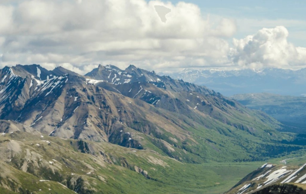 Aerial view of snow-capped Alaska Range peaks and green valleys on a Denali flightseeing tour